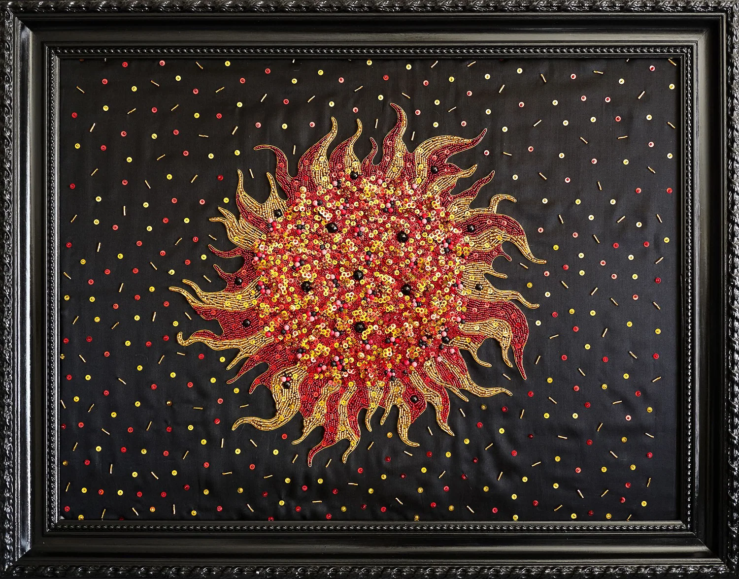 Soleil en éruption brodé de perles rouges et dorées sur soie noire, cadre noir sculpté