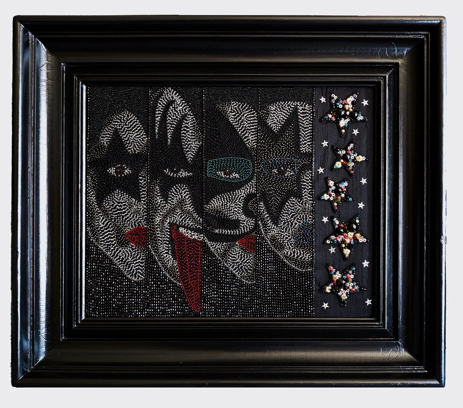 Les visages du groupe KISS brodés de perles noires et colorées, cadre noir