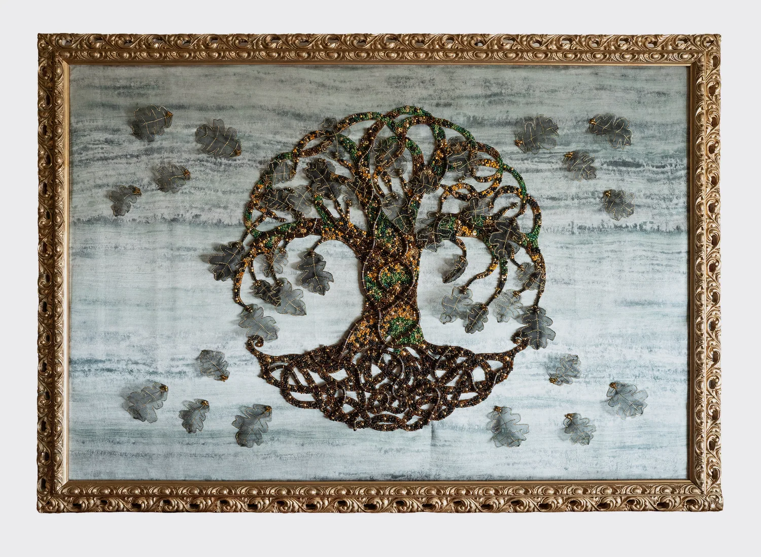 L’Arbre Monde brodé de perles dorées, vertes et brunes sur un fond de soie grise, cadre doré baroque